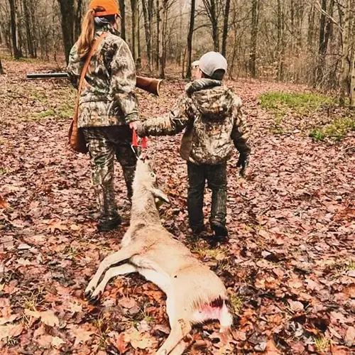 A photo of 2 children using the DeerForce One Hand Drag to pull a deer.